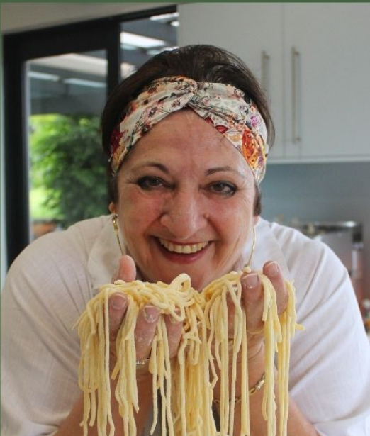 Nilla holding fresh handmade pasta in her kitchen